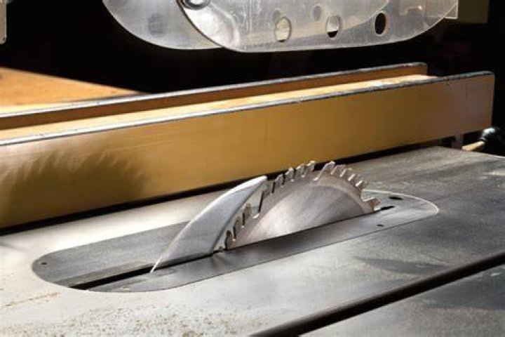 What does the spreader riving knife do on a table saw?
